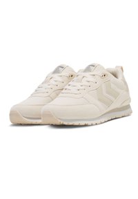 Beige idrettssko med en strukturert overdel, snøring, logodetalj og en kontrastfarget gummisåle. Inkluderer glatte og semskede materialer.