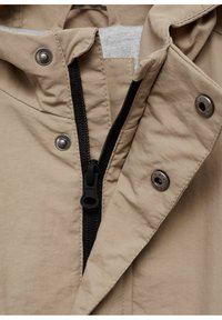 Bežna jakna z zadrgo, črna zadrga, kovinskimi gumbi in sivo notranjo oblogo. Tkanina ima gladko teksturo.