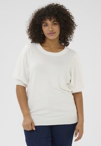 Cream-colored short-sleeve sweater with a round neckline and soft, relaxed fit. Features textured, puffed sleeves and ribbed hem.