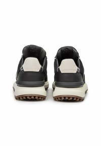 Zapatillas de ante y cuero negro con un acento gris claro, que cuentan con una suela blanca gruesa y una suela exterior de color marrón texturizado para mayor tracción.