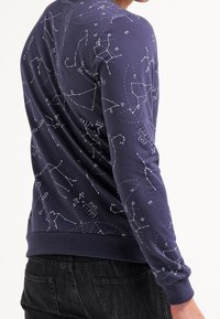 Felpa blu navy con maniche lunghe, caratterizzata da costellazioni bianche e simboli matematici stampati su tutto il tessuto, con polsini a coste e orlo inferiore.