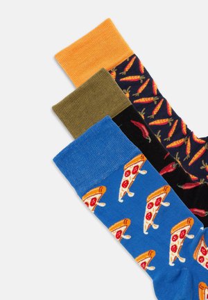 Trois paires de chaussettes : orange, vert olive et bleu avec un imprimé de pizza. La chaussette bleue présente un motif de tranches de pizza pepperoni.