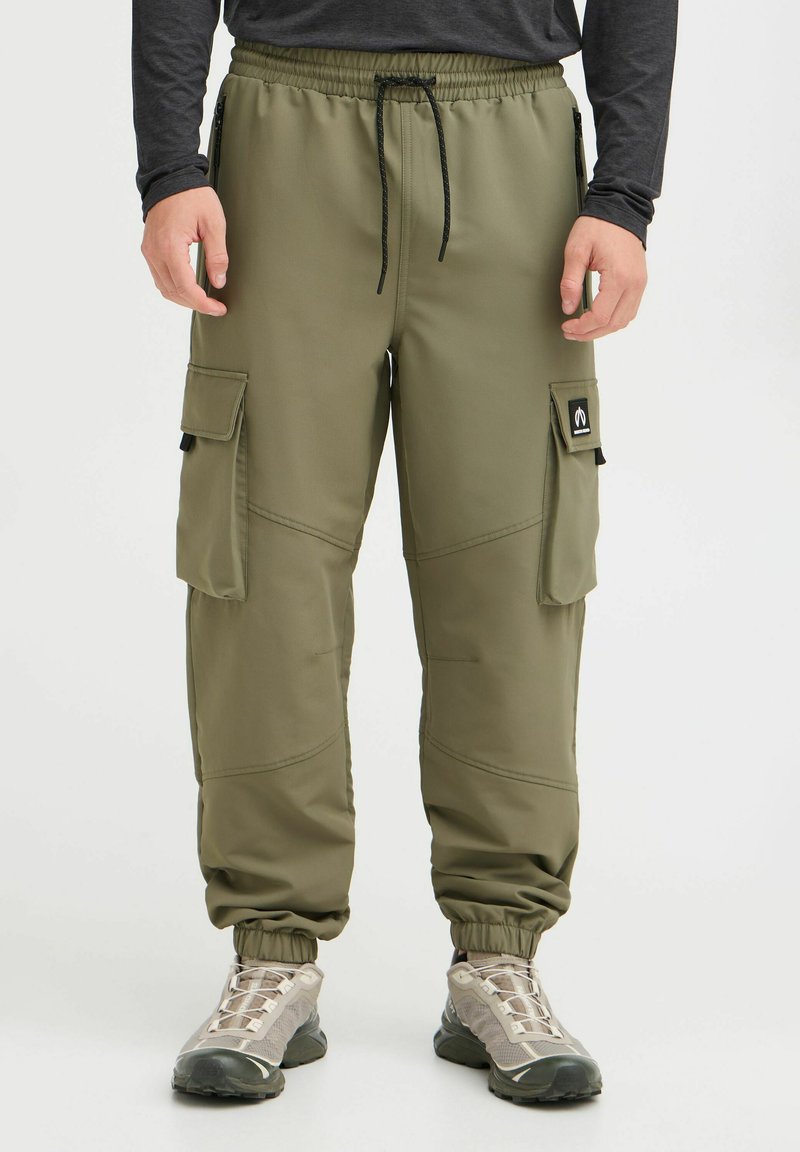 Pantalons cargo vert olive avec ceinture élastique, cordon de serrage et plusieurs poches. Tissu doux avec coutures visibles et poignets élastiques.