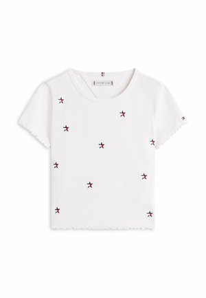 Top corto bianco a maniche corte con bordi smerlati, decorato con piccoli motivi di stelle blu navy e rosse su tutto il tessuto.