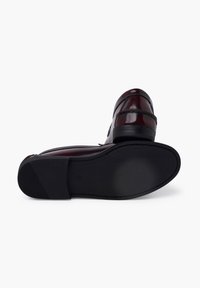 Dark burgundy leather shoes with a smooth finish. Classic moccasin design featuring decorative stitching. Rubber sole with textured grip.