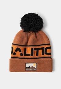 Brązowa dzianinowa czapka z pomponem z dużym czarnym pomponem na czubku, pomarańczowym logo "KOALICJA" i czarnymi akcentami. Posiada naszywkę z logo.