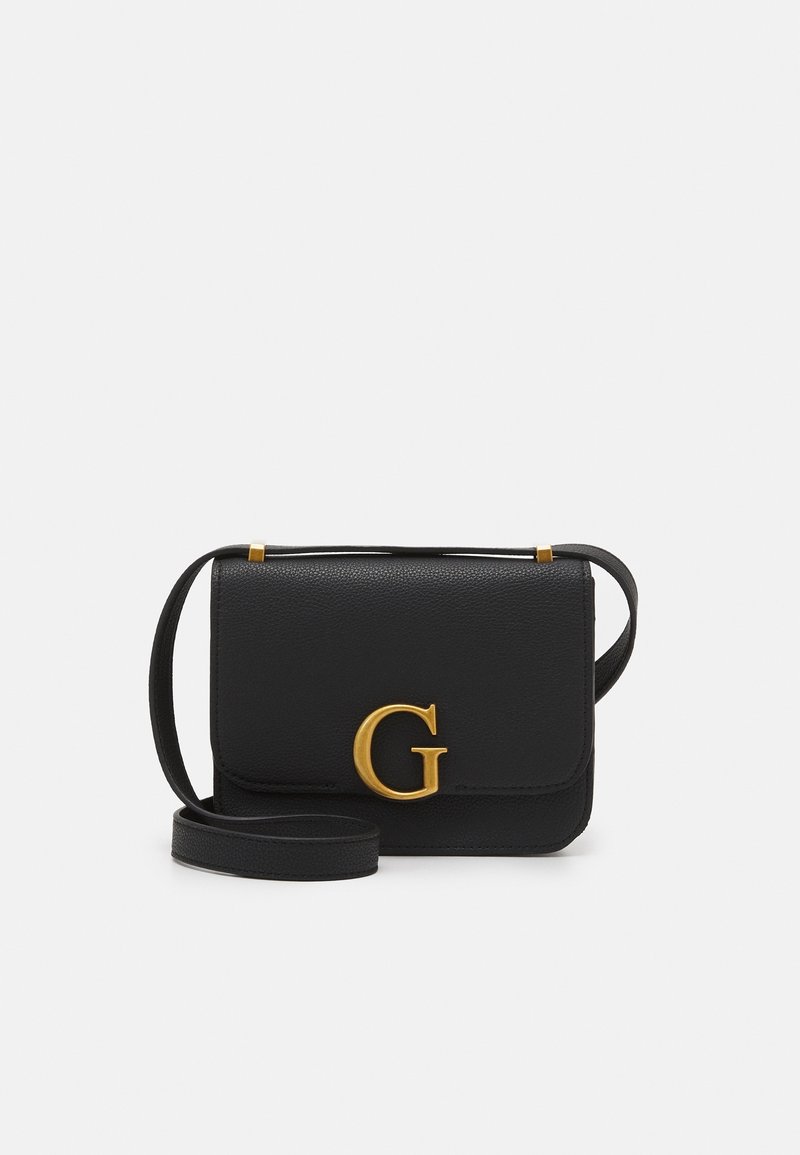Černá kožená crossbody taška se zlatým „G“ zapínáním a nastavitelným popruhem na bílém pozadí.