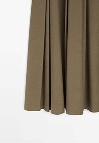 Jupe fluide vert olive avec des plis doux, ourlet au genou et texture de tissu lisse sur fond blanc.