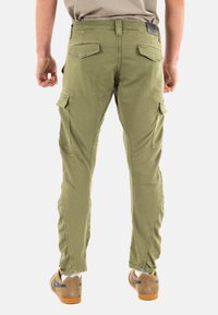 Pantaloni cargo verde oliva con due tasche posteriori e tasche laterali; presentano gambe dritte e cuciture rinforzate. Adatti per l'uso all'aperto.
