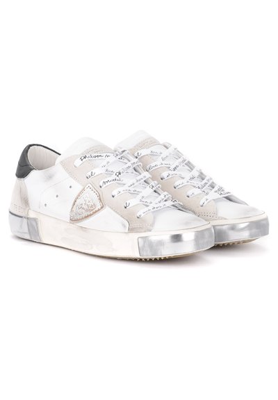 Sneaker bianche in pelle con accenti in suede grigio, punta metallica e testo scritto a mano sui lacci. Presentano una punta arrotondata e una suola testurizzata.