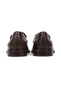 Brązowe skórzane buty o gładkim wykończeniu, z zamkniętym tyłem i niskim obcasem. Subtelne detale przeszyć wzdłuż krawędzi.