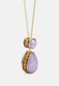 Gouden ketting met een druppelvormige lila steen en een ronde lila accent, omgeven door gefacetteerde bruine stenen in een geometrische opstelling.