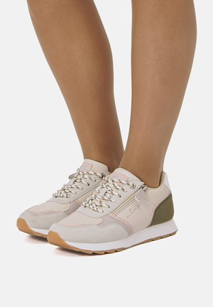 Beige Sneaker mit hellrosa Akzenten, strukturierter Stoff, metallische Ösen und eine grau-grüne Ferse. Leichtes Design und Gummisohle.