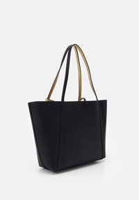Sac fourre-tout en cuir texturé noir avec deux anses d'épaule, doté d'une doublure intérieure beige et d'une fermeture simple à boucle sur un fond blanc uni.