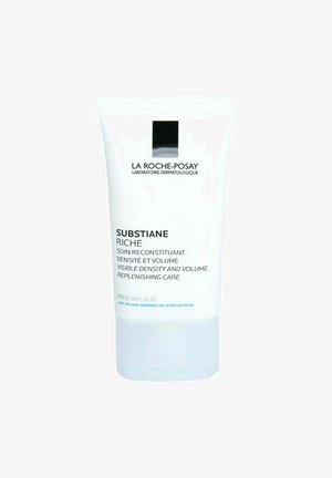 La Roche-Posay Substiane Riche Tube, aus weißem Kunststoff mit schwarzem und blauem Text, hat eine durchsichtige Basis und eine abgerundete Oberseite für eine einfache Entnahme.