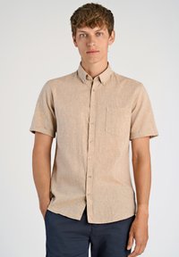 Camicia corta con maniche corte di colore beige, con colletto a punta e taschino. Tessuto morbido e testurizzato, con un leggero motivo mélange e bottoni in madreperla.