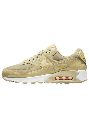 Beiger Nike Air Max Sneaker mit Mesh, Lederpanelen, sichtbarem Luftelement in der Sohle und gelben Branding-Details auf weißem Hintergrund.