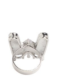 Anillo de plata con un diseño intrincado, acentos texturizados y una banda ancha. La forma recuerda a una mariposa con detalles en las alas.