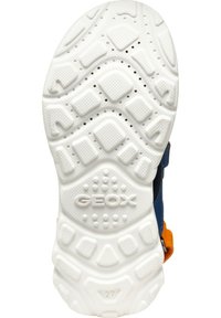 White rubber sneaker sole with textured surface. Features a slight arch, circular and rectangular patterns, and vent holes, labeled "GEOX."