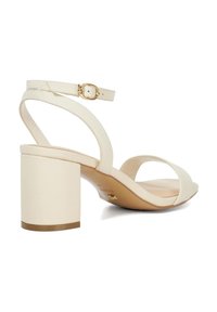 Crème open teen hak sandaal met een blokhak, voorzien van dunne banden en een gespsluiting. Gladde textuur, minimalistisch ontwerp.