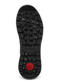 Czarna gumowa podeszwa buta z wytrzymałym wzorem, z heksagonalnymi teksturami i wystającymi trójkątnymi kształtami; czerwona akcent w centrum.