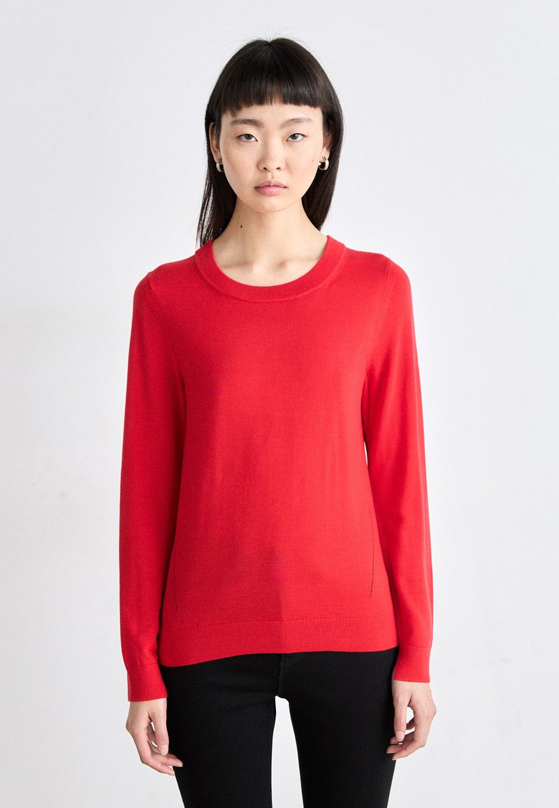 Κόκκινο πλεκτό πουλόβερ με μακριά μανίκια, στρογγυλή λαιμόκοψη και απαλή υφή. Στενή γραμμή με ριμπ μανσέτες και στρίφωμα.