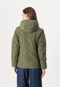 Giacca imbottita verde oliva con cappuccio, caratterizzata da una texture liscia e una silhouette strutturata. Design senza bottoni, finitura morbida e maniche lunghe.
