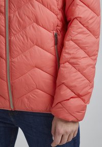 Koralfarvet quilted puffer-jakke med et chevronmønster, der har en frontlynlås og sidelommer, lavet af glat syntetisk materiale.