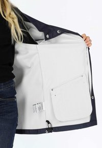 Giacca esterna blu navy con fodera interna bianca, caratterizzata da una tasca con zip e un'etichetta, mostrata con la parte frontale aperta e una texture liscia.