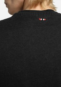 Maglione nero lavorato a maglia con colletto a coste e una piccola striscia di accento rosso, bianco e blu sul retro. Texture liscia, design aderente.
