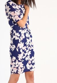 Blommig klänning i marinblått med rosa bladmönster, korta ärmar, knälång, tillverkad av lättviktig tyg, mjuk textur.