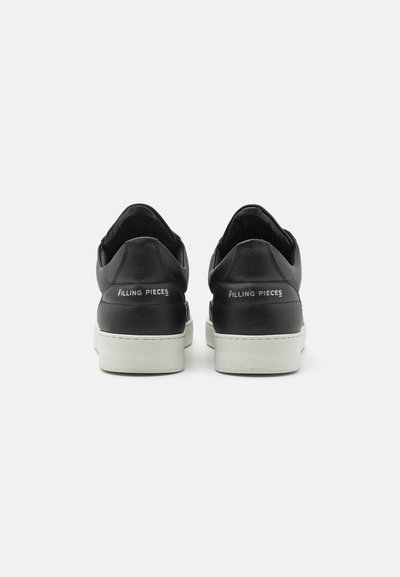Černé kožené tenisky s texturovaným povrchem, bílé gumové podrážky a brandingem „FILLING PIECES“ na patě. Zaoblený design a minimální doplňky.