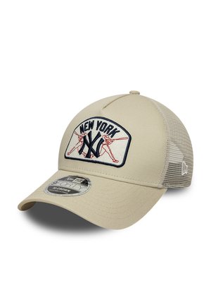 Beige mesh baseball cap with curved brim featuring New York Yankees logo and red outlined baseball player embroidery on front panel.