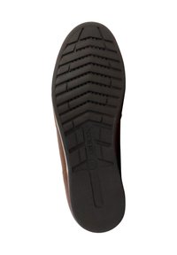 Semelle de chaussure avec une surface en caoutchouc noir texturé, présentant des motifs de bande de roulement en zigzag pour une adhérence, ainsi qu'un logo circulaire en relief.