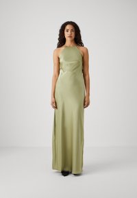 Satin, be šoninėmis rankovėmis maxi suknelė šviesiai žalios spalvos, turinti prigludusią siluetą ir šonines jungtis judėjimui. Minimalistinis dizainas su sklandžiu paviršiumi.
