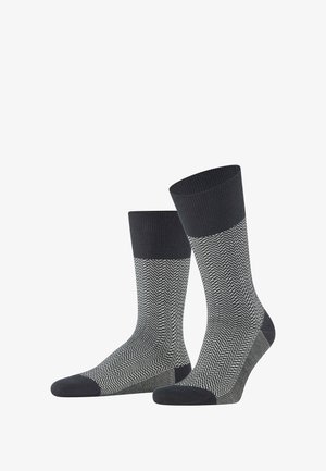 Chaussettes en coton arborant un motif en chevron gris foncé et blanc, avec un revers côtelé gris foncé uni et un renforcement à la pointe pour plus de durabilité.