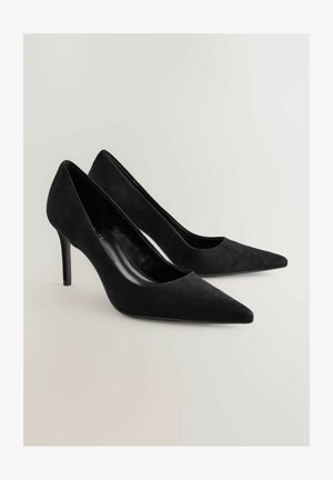 Sorte ruskinds højhælede sko med spidse tæer og en elegant finish. Har en slank, afsmalet hæl og en glat indersål.