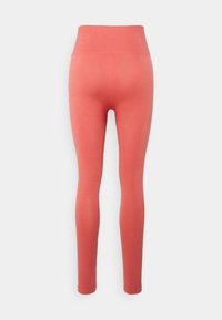 Leggings cor-de-rosa com uma cintura alta e texturizada. O material parece elástico e suave, projetado para uma silhueta justa sem padrões.