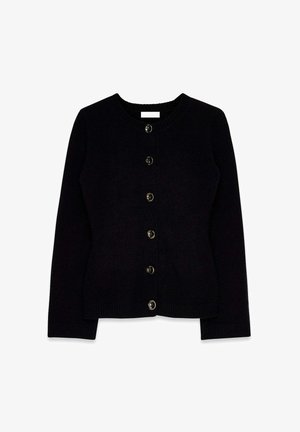 Melna kardigāna jaka ar apaļu apkakli, garām piedurknēm un priekšpusi aizveramu ar sešiem dekoratīviem pogām. Ribota apakša un piedurkņu gali.