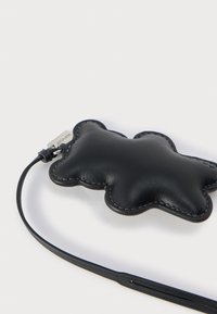 Fekete bőr kulcstartó felhő alakban, tónusos varrással és rögzítőhurkos kialakítással. Simább textúra, fényes fémtábla díszíti.