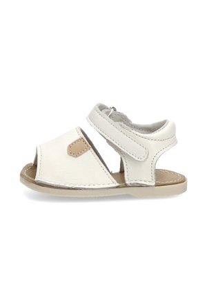 Sandalia blanca de cuero para bebé con punta abierta, correa ajustable en el tobillo, suela beige y detalle marrón en el lateral.