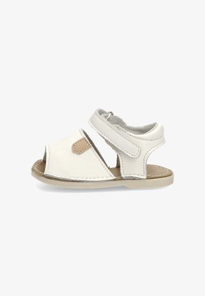 Sandalia blanca de cuero para bebé con punta abierta, correa ajustable en el tobillo, suela beige y detalle marrón en el lateral.