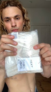 Set di asciugamani bianchi confezionati in plastica trasparente con etichette. La consistenza degli asciugamani sembra morbida; visibile il marchio "NEXT" e i dettagli del codice a barre.