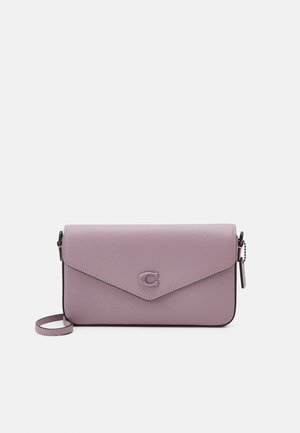 Lille rektangulær violetlæder crossbody taske med klaplukning og håndledsrem på ensfarvet lyst baggrund.