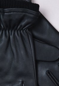 Black leather glove with a textured surface, elasticated wrist, and knitted black cuff. Features stitched detailing on the palm.