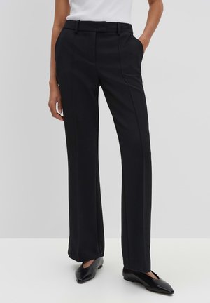Black tailored trousers with a straight leg, flat front, belt loops, and side pockets, made from a smooth fabric. Worn with black pointed shoes.