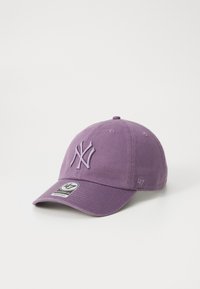 Fialová baseballová čepice s vyšitým logem New York Yankees vpředu a malou značkovou nálepkou na kšiltu.