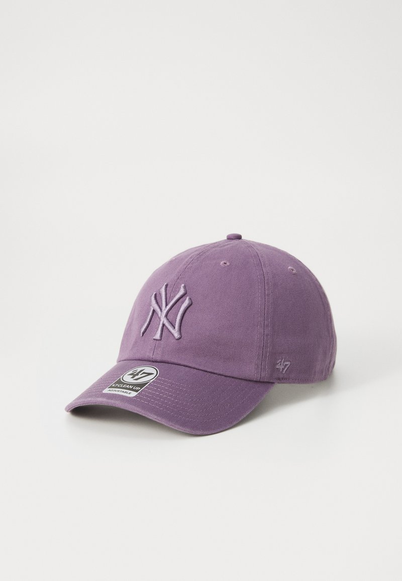 Fialová baseballová čepice s vyšitým logem New York Yankees vpředu a malou značkovou nálepkou na kšiltu.