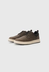 Chaussures en cuir marron avec une finition texturée, accents en maille noire, design à lacets et une semelle en caoutchouc crème contrastante.