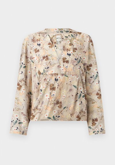 Φλοράλ μπλούζα σε ανοιχτό μπεζ ύφασμα, με βαθύ V-λαιμόκοψη, μακριά μανίκια και σφηκοειδή μέση. Το σχέδιο περιλαμβάνει πολύχρωμα λουλουδένια μοτίβα.